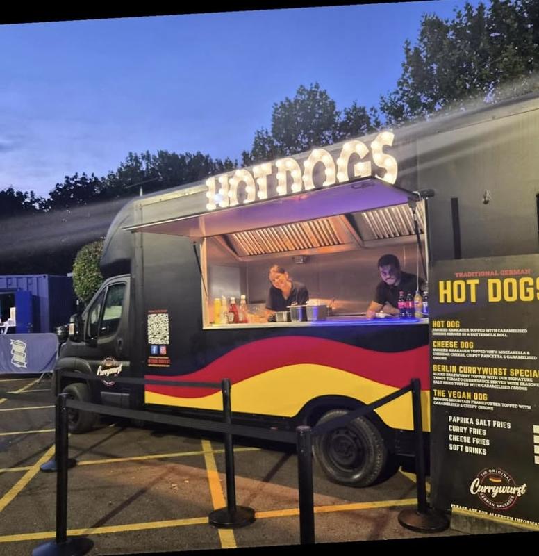 The Currywurst truck lit up at an outdoor event